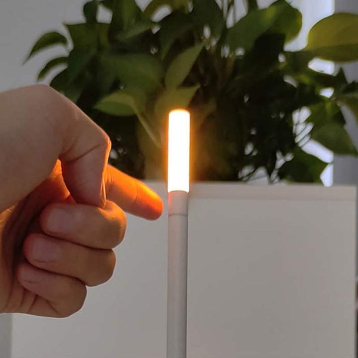 Warm gold LED night lamp on bedside table, touch-activated and cordless, for ambient bedroom lighting and modern home décor.