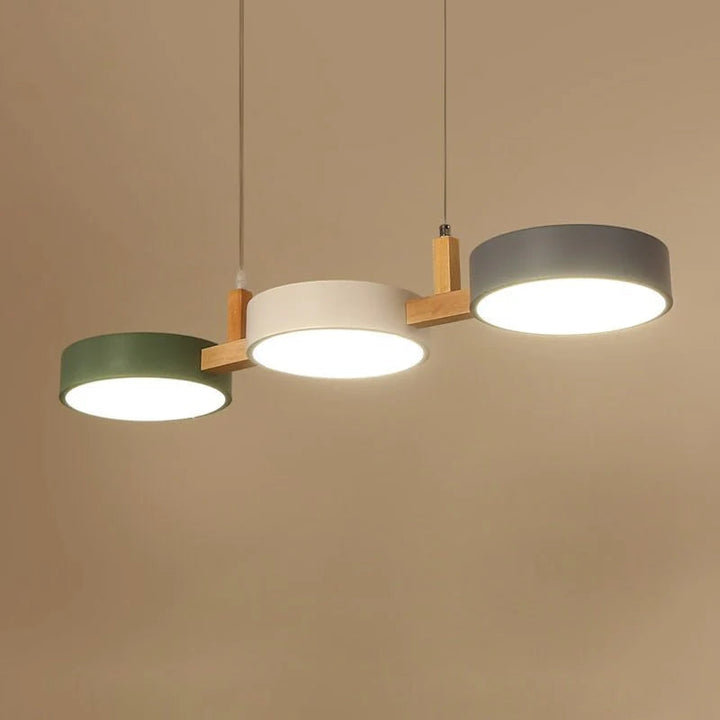 Warm glow of Nordic cylinder pendant light with sleek design and wooden connectors.