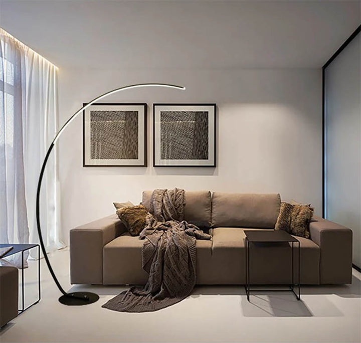 Dimmable ARC Floor Lamp with curved light bar next to modern grey sofa, ideal for ambient lighting in living spaces.