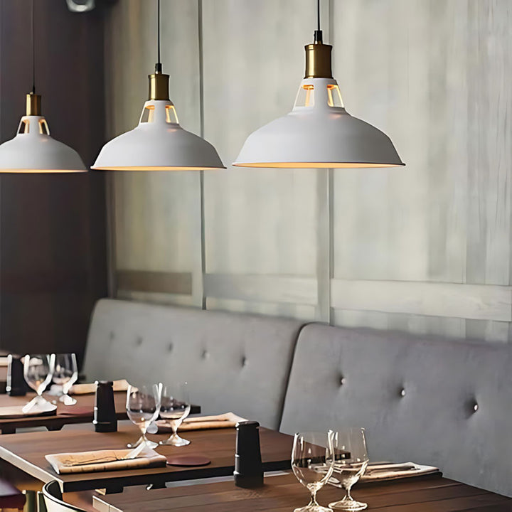 Modern UK restaurant interior with white adjustable pendant lights, tables, and chairs.