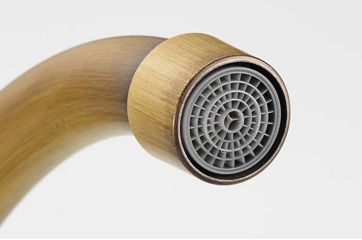 Bronze kitchen tap with a gray central component on a white background