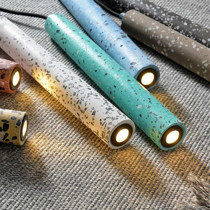 Close-up of BETON terrazzo cement pendant lights in green, white, and black