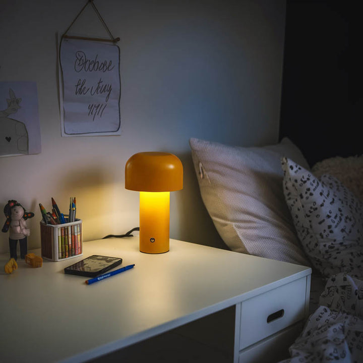  Yellow BOLETE cordless LED mushroom lamp on child's desk, soft night light, metal build, ideal for bedroom or study.