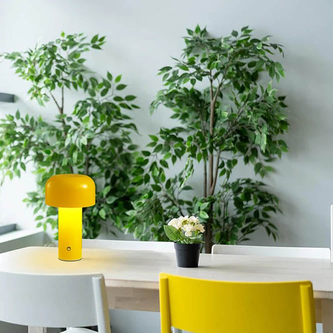 Modern yellow cordless mushroom lamp on uk dining table, warm LED glow, portable metal design for indoor or outdoor use.