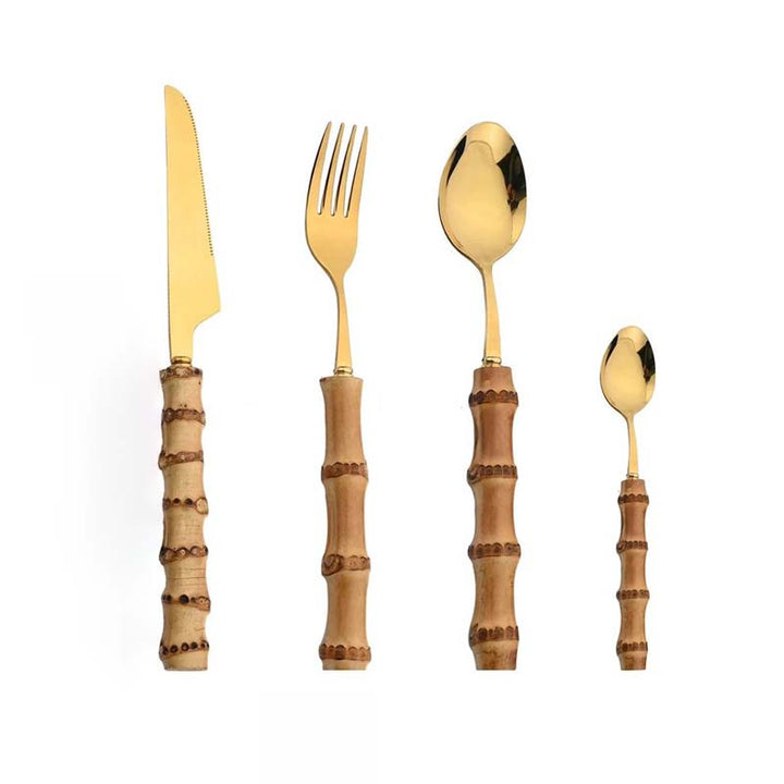 Set of gold cutlery with wooden handles on a white background
