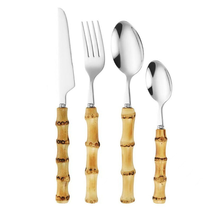 Set of silver cutlery with bamboo handles on a white background