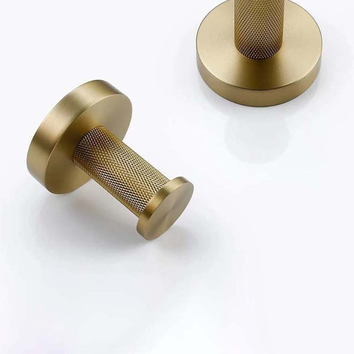 Two gold-colored door handles on a white background
