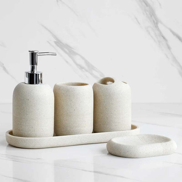Bathroom accessory set with textured cream containers on a white surface