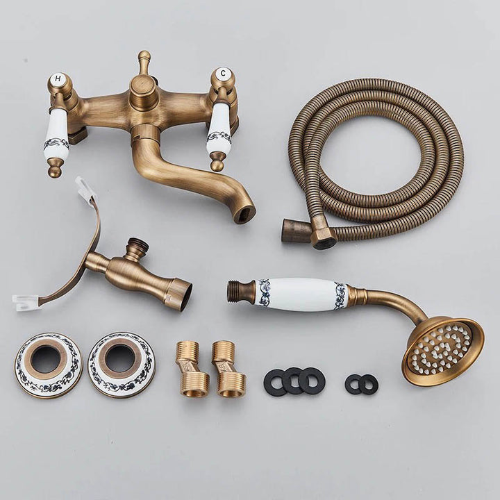 Disassembled vintage bronze bathtub faucet set including hoses, handheld shower, and installation parts