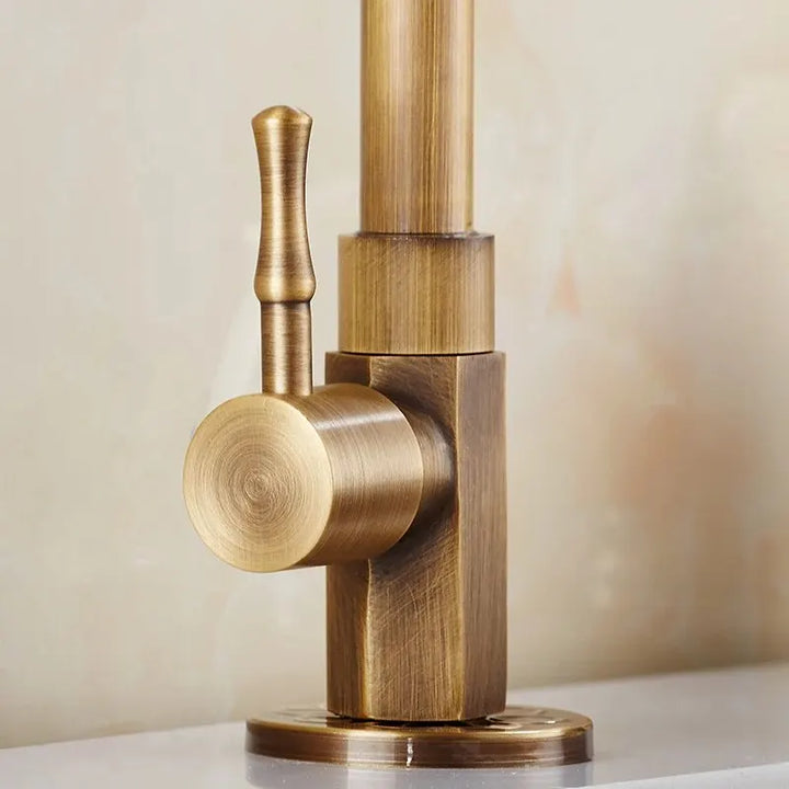 Brass kitchen faucet on a neutral background