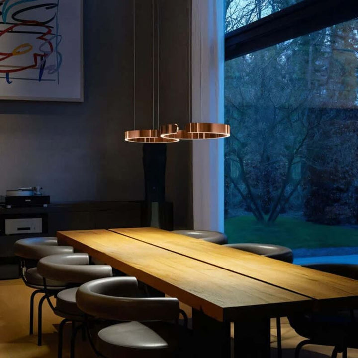 Rose gold circular LED chandelier over wooden dining table – modern Nordic ceiling light