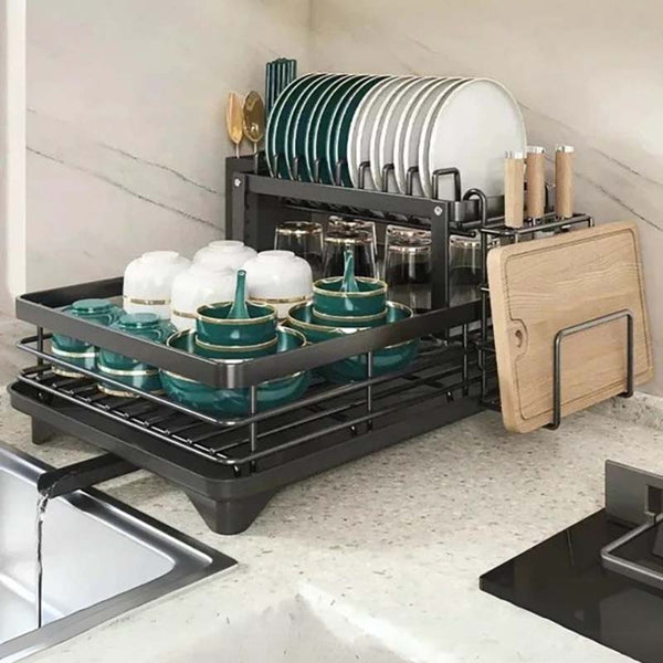 Dish rack with dishes, glasses, and cutting boards on a kitchen counter.