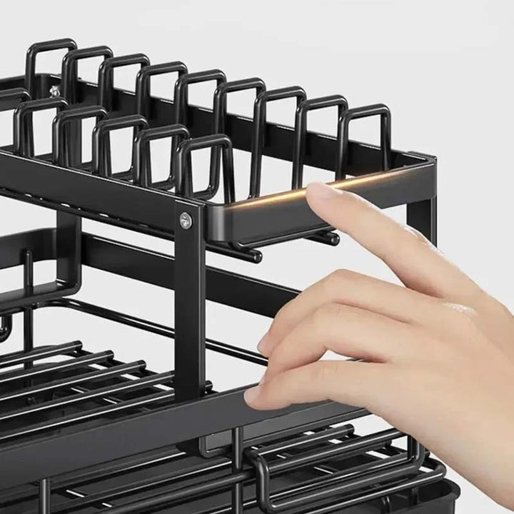 Black metal kitchen rack with a hand interacting with it on a light gray background