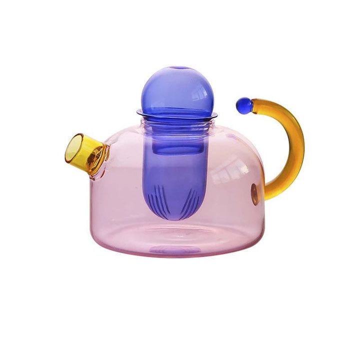 Colorful glass teapot with a pink body, blue lid, and yellow handle on a white background