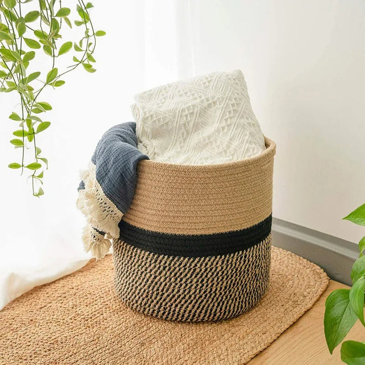  Natural jute and black cotton rope basket used for blanket storage in a bright Scandinavian-style room.