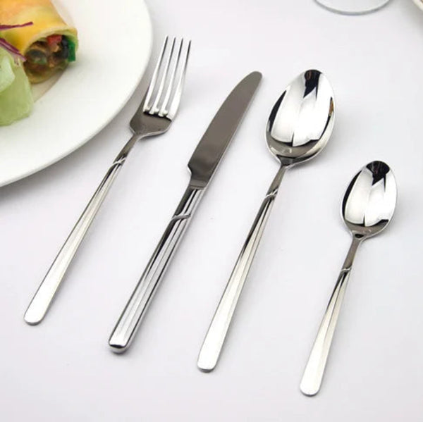 Set of silver cutlery including fork, knife, and two spoons on a white surface.