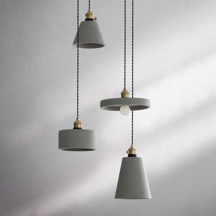 Set of modern concrete pendant lights with brass fittings in varied geometric shapes