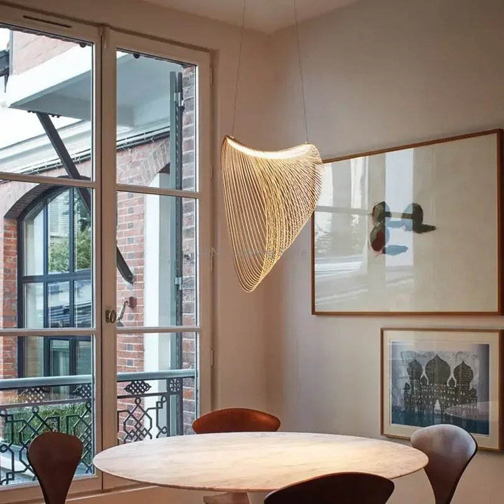 ENBIRK wooden pendant light above dining table, Scandinavian interior with warm lighting and curved beech wood silhouette.