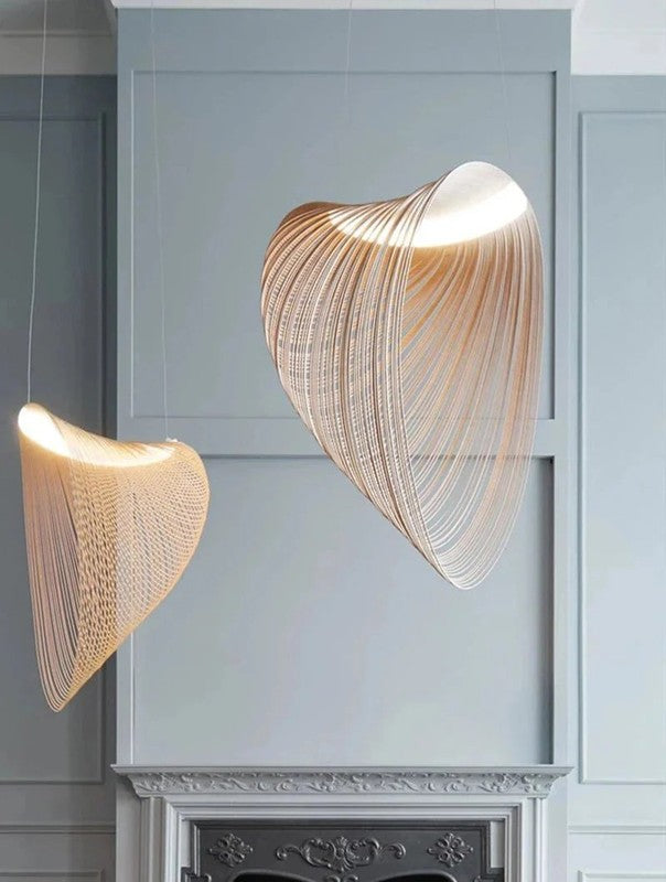 Two modern pendant lights hanging against a light gray wall.