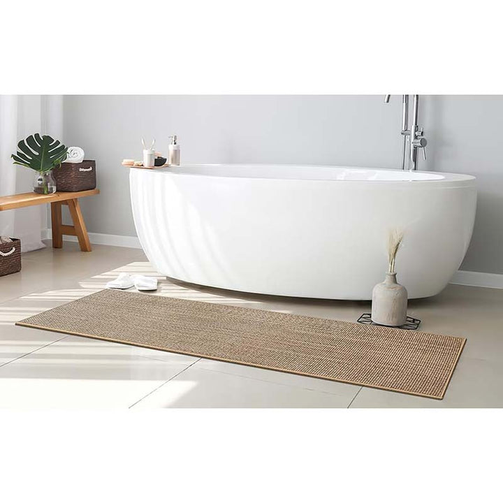 Bathroom with a freestanding bathtub, easy clean woven mat, and minimal decor.