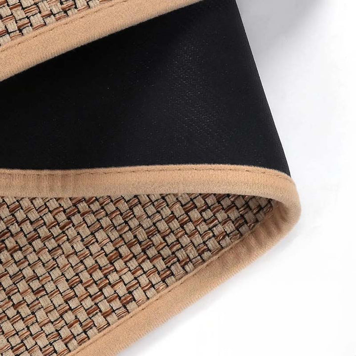 Close-up of a woven kitchen mat with a black center and beige edges on a white background