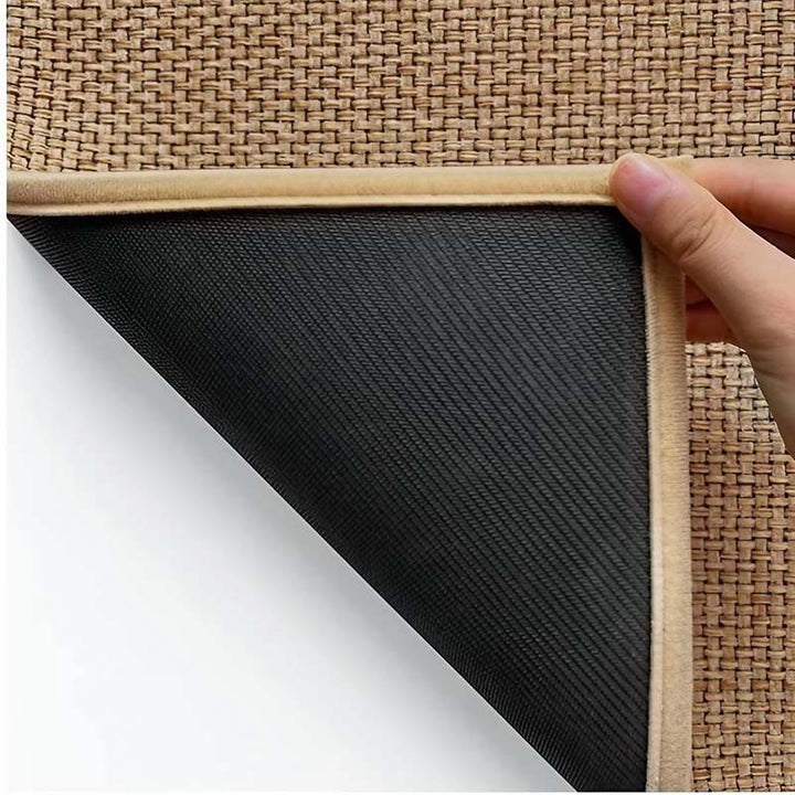 Hand holding a woven kitchen mat with a black backing