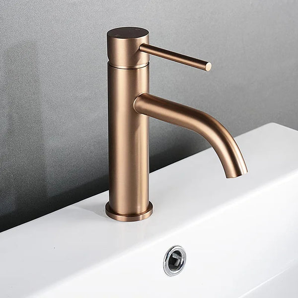 Brushed rose gold mixer tap installed on white ceramic basin, sleek modern style.