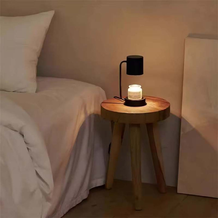 Compact black candle warmer lamp on bedside table, warm ambient light for bedroom relaxation