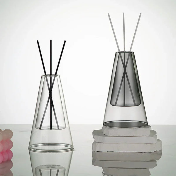 Clear and grey glass essential oil diffusers with reed sticks, modern minimalist aromatherapy décor