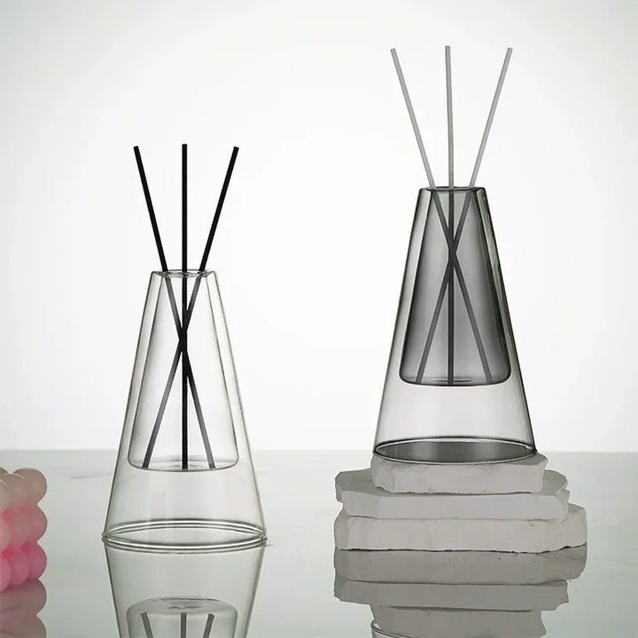 Clear and grey glass essential oil diffusers with reed sticks, modern minimalist aromatherapy décor