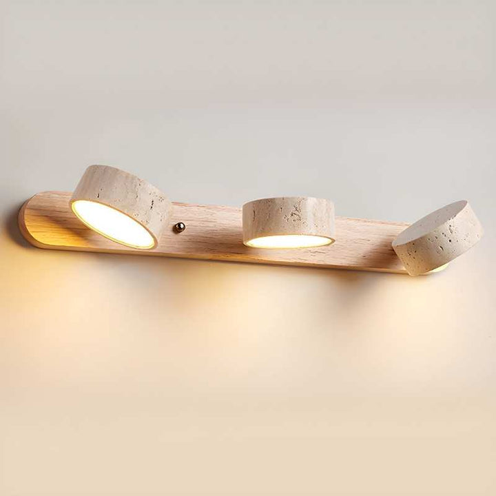 Wooden wall light fixture with three circular lights on a neutral background