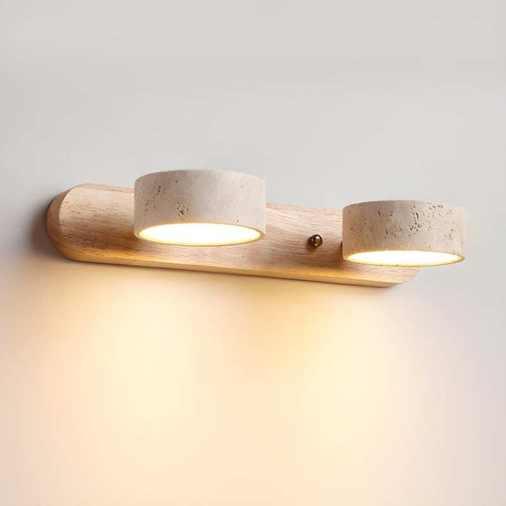 Wall-mounted light fixture with two cylindrical lights on a plain wall.