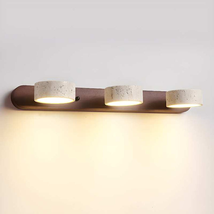 Modern wall-mounted light fixture with three cylindrical lights on a plain wall.