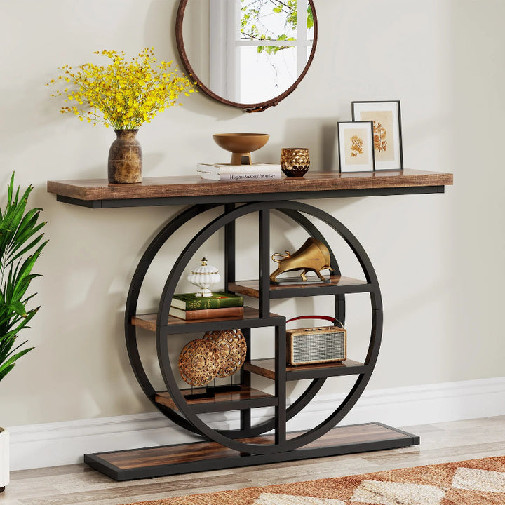 Decorative console table with circular metal base and wooden top in a room setting.