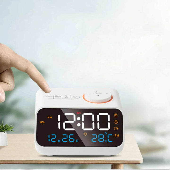Person touching the top buttons of white FM Radio LED Alarm Clock with LED display showing time, date, and temperature.