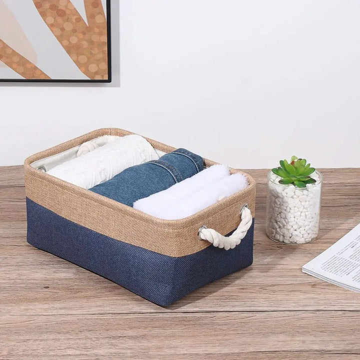 Storage basket with clothes on a wooden surface, framed picture in the background