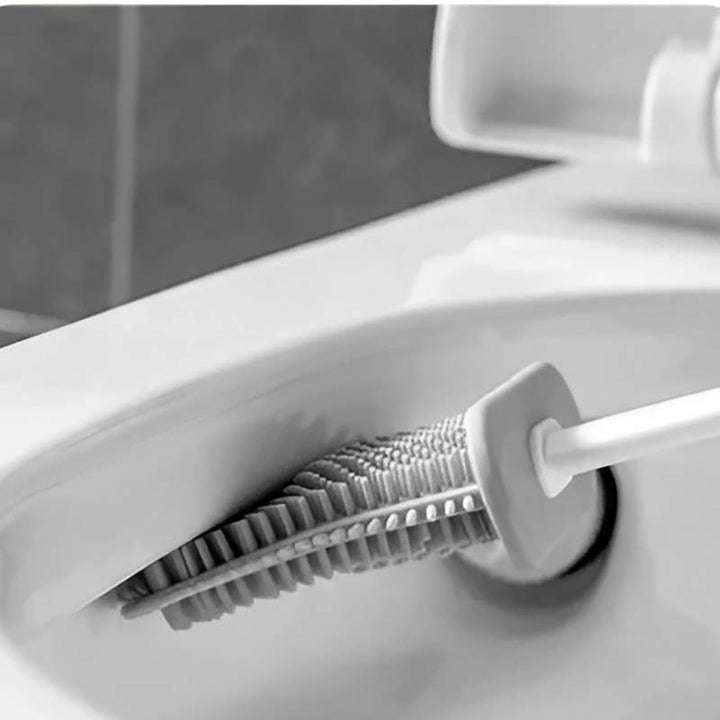 Close-up of a toilet brush with bristle head and white handle inside a toilet bowl.