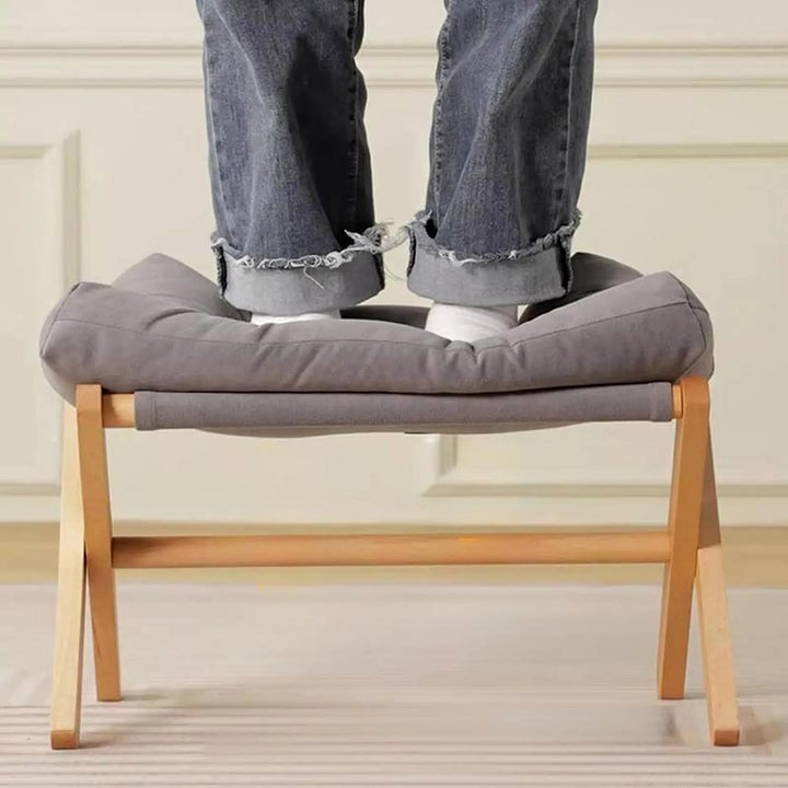 Sturdy grey cushioned ottoman supporting person standing, highlighting durable wood construction and high-weight capacity (150kg / 330 lbs).