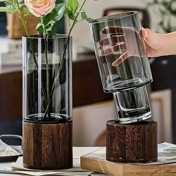 Tinted glass propagation vase being removed from solid wood base, ideal for UK minimalist interiors.