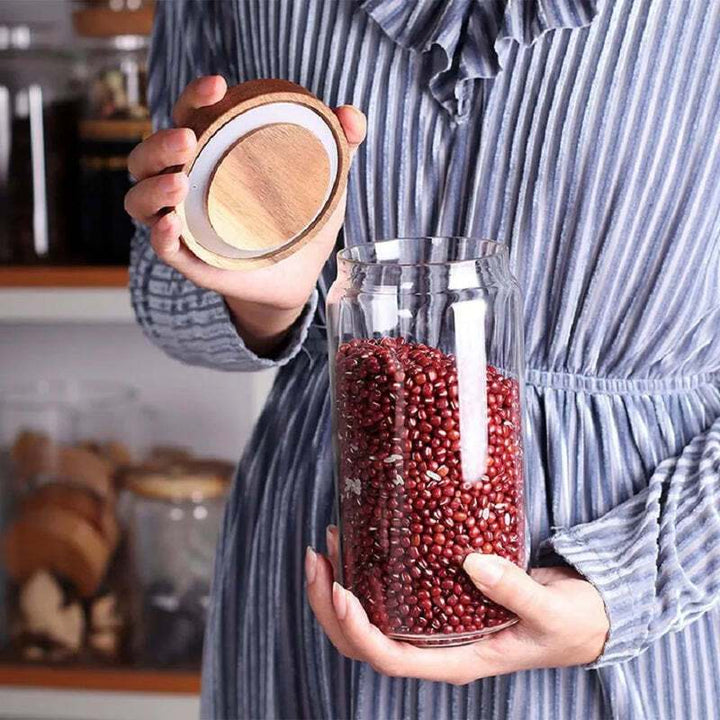 Woman holding airtight glass jar with bamboo lid, filled with red beans