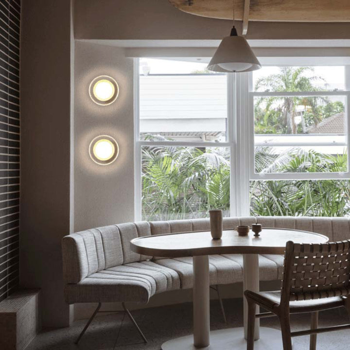 Pair of ILD glass sconces with gold base in modern kitchen dining area, adding warm ambient lighting.