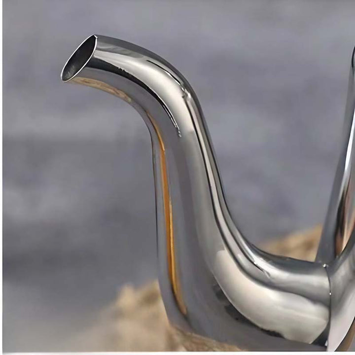 Close-up of a shiny metal exhaust pipe against a blurred background