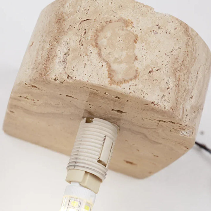 Close-up of yellow travertine stone lamp base with G9 LED bulb fitting