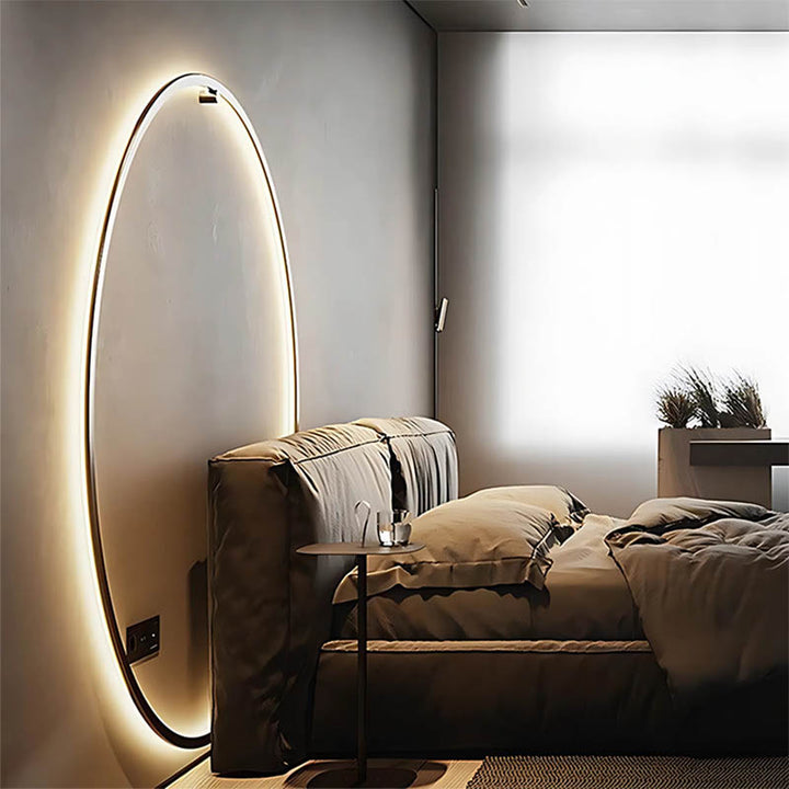 Slim black-frame USB wall sconce above bed, emitting soft glow, ideal for minimalist UK bedrooms
