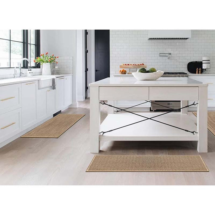 Modern kitchen with a white island, light-coloured floor and kitchen mat.