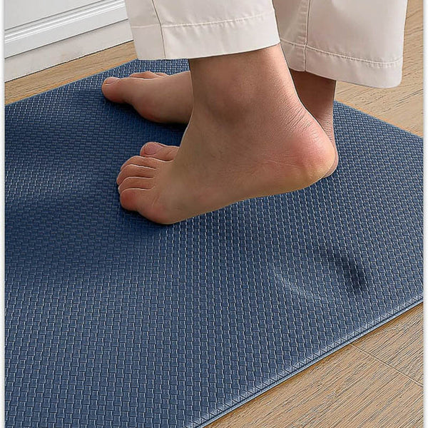 Person standing on a blue textured kitchen mat with feet visible