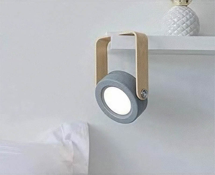 Folded LYKT LED lamp used as angled spotlight on shelf, compact and modern for versatile placement.