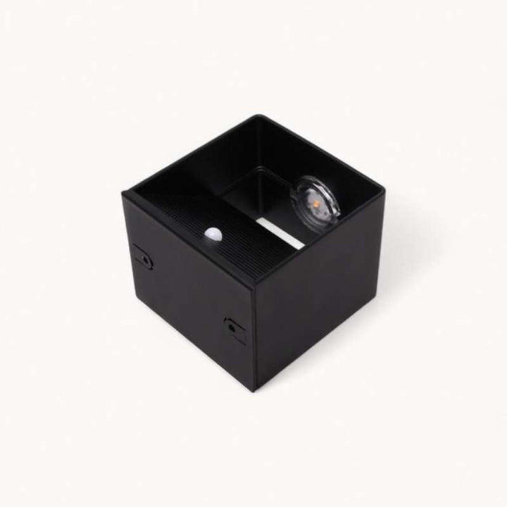Open view of black LUMA LED wall lamp showing motion sensor and USB-C rechargeable light source