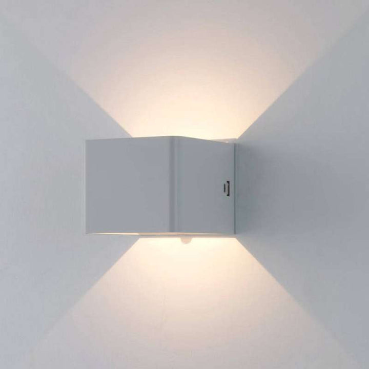 White LUMA LED wall lamp glowing with dual light beams, motion sensor for automatic illumination