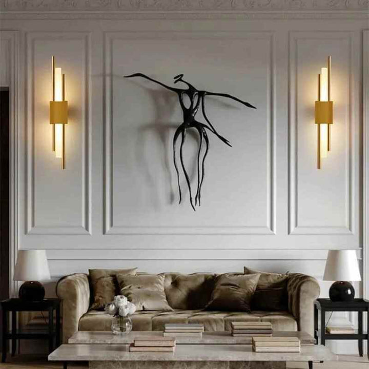 Modern gold LED wall lights in living room beside black abstract sculpture